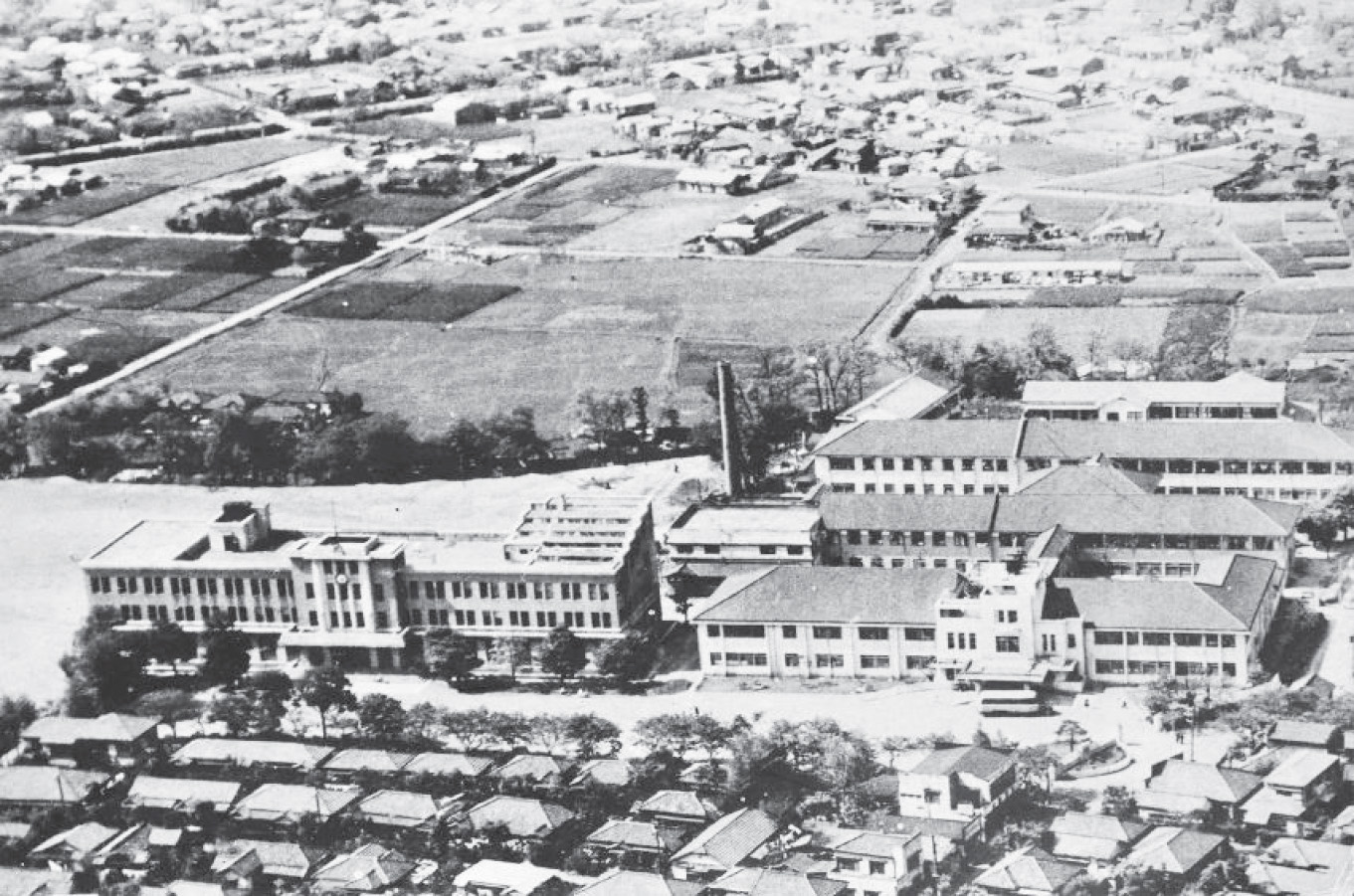 写真3：医学部と病院外来棟全景。<br>病院後方が第一病棟，その背後が第2病棟と思われる（27回生卒業アルバム「機上から」による）